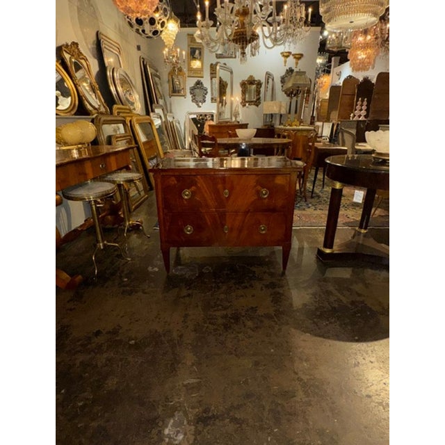 The 19th c. German Biedermeier Mahogany Commode is an antique piece of furniture that exudes elegance and craftsmanship....