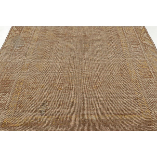 Hand-knotted in wool, this antique 6x10 Khotan rug originates from East Turkestan circa 1920–1930. The design features a...