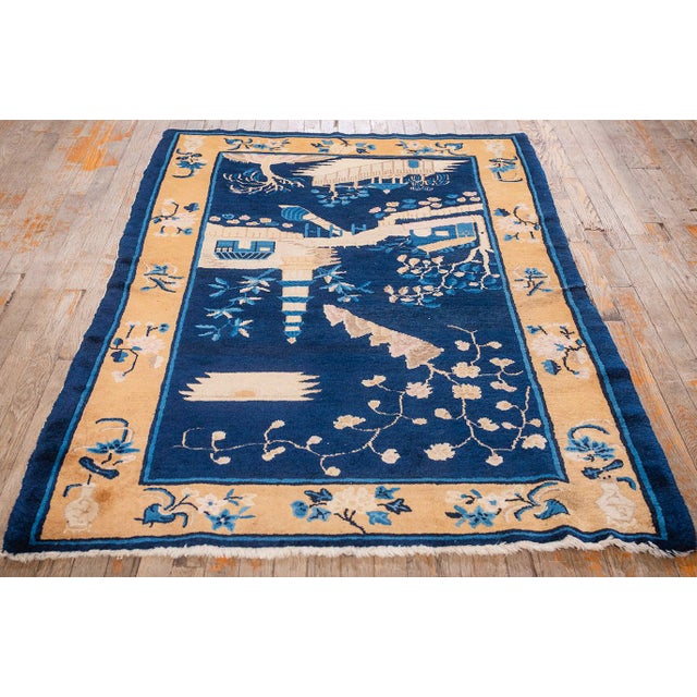 This antique rug is an Art Deco-style Chinese Peking piece from circa 1920. It is characterized by its sophisticated "blue...