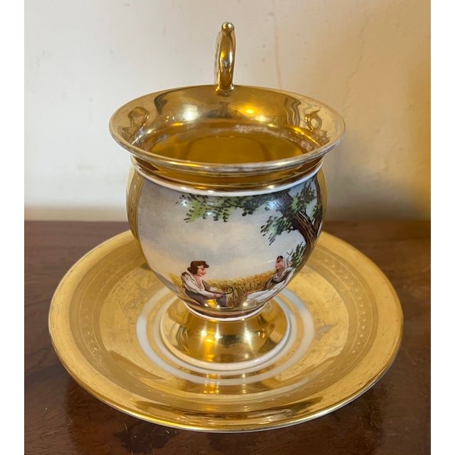 Antique early 19th century French Empire Paris porcelain tea cup and saucer. Decorated with a hand painted landscape scene...