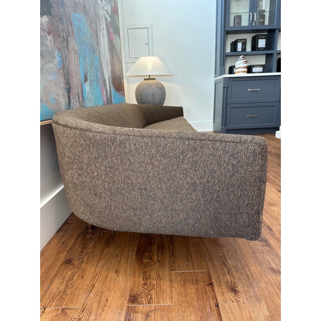 This elegant curved sofa combines modern minimalism with mid-century sophistication. Upholstered in a sleek charcoal gray...