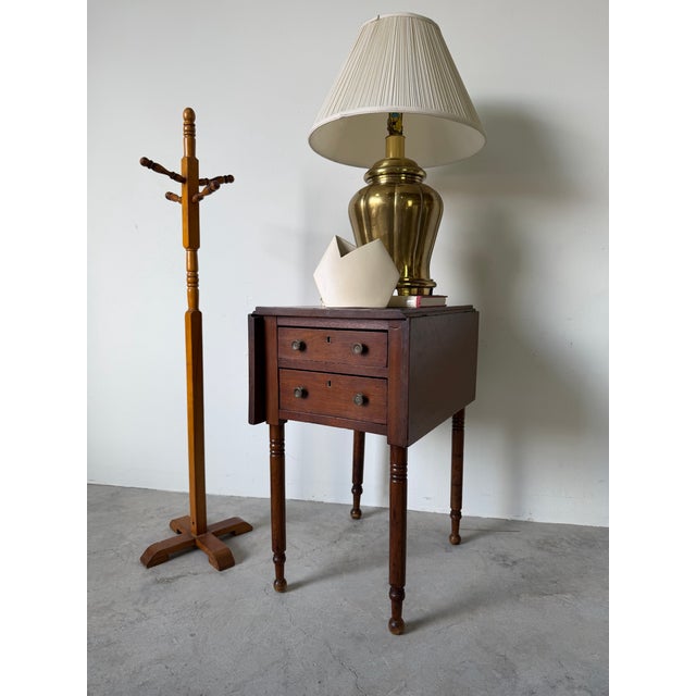 Elegant antique walnut drop-leaf table featuring a warm, rich patina and classic early craftsmanship. This piece is...