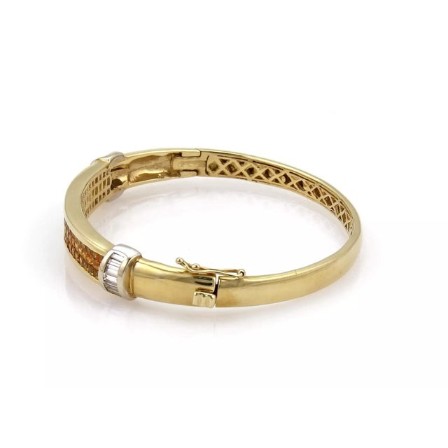 An elegant and stunning bangle bracelet with exquisite detail and gorgeous stones, it is crafted from 14k yellow gold in a...