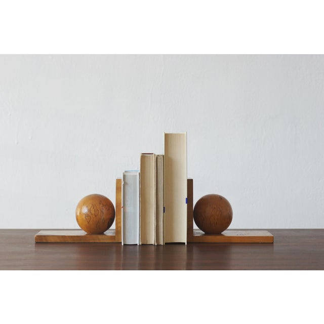 A pair of wooden bookends with a geometric, sculptural form, embodying the aesthetic of postwar modernism. Each piece is...