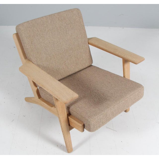 Hans J. Wegner lounge chair made of solid soap treated oak. New upholstered with boucle. Model 290, made by GETAMA. This...