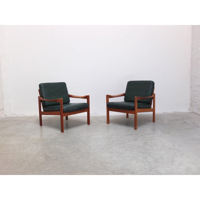 Fabulous pair of easy chairs designed by Illum Wikkelsø around 1960. Solid teak frames with beautiful sculpted armrests....