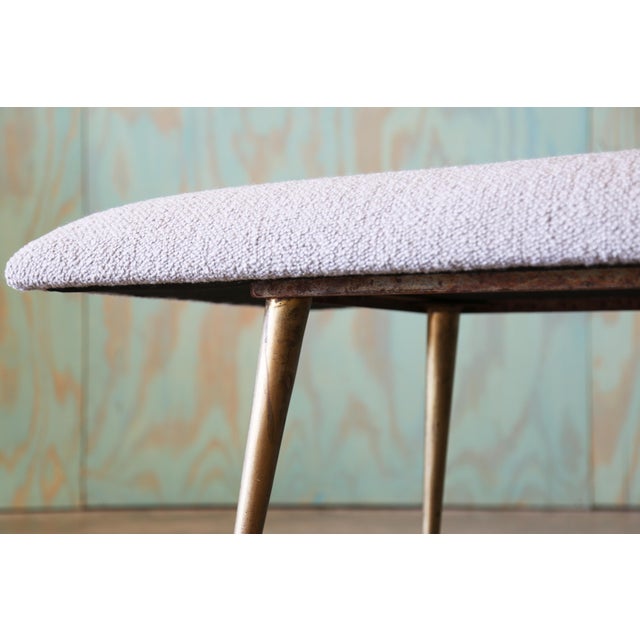 A unique bench consisting of an iron frame suspended by tapered splayed brass legs covered in a mushroom shaped wool...