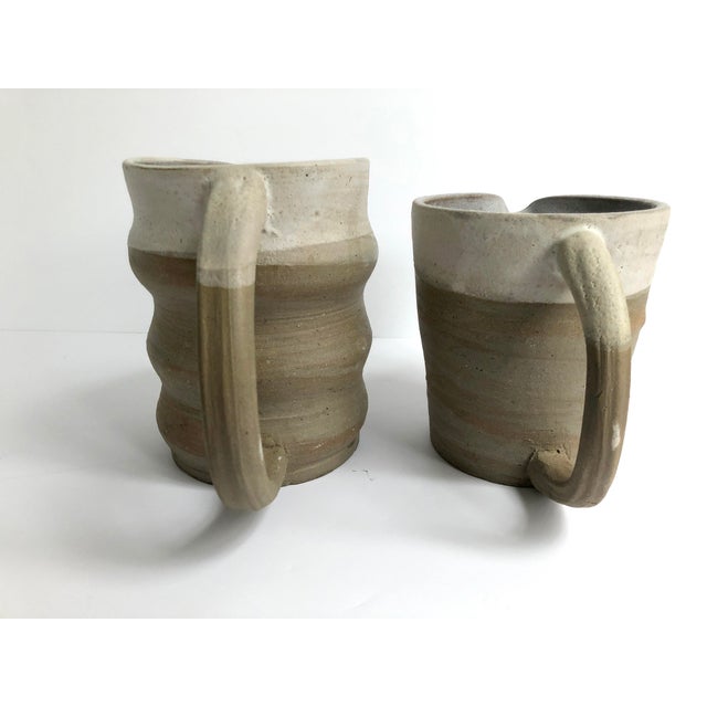 A unique and stunning pair of organic modern pottery pitchers. The minimal silhouette and neutral palette appeal to a...