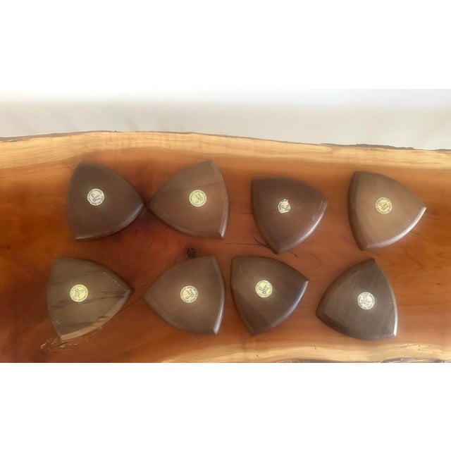 A striking set of eight mid-century modern coasters featuring a distinctive teardrop or shield-like silhouette. Each piece...