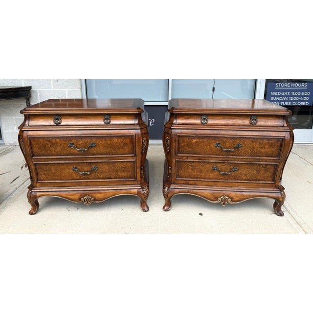 This impressive pair of Orleans International French-style nightstands features richly figured burled walnut drawer...