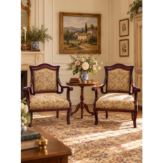 An elegant pair of French Provincial style mahogany armchairs featuring graceful cabriole legs, carved serpentine crest...