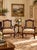 An elegant pair of French Provincial style mahogany armchairs featuring graceful cabriole legs, carved serpentine crest...