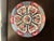 Pair of Tosho decorative plates, featuring a central basket of flowers surrounded by segmented panels of pink, red, and...