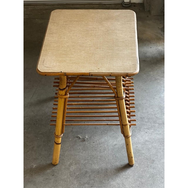 Vintage bamboo and rattan side table from the 1970s, featuring a built-in double magazine rack. Its natural bamboo frame...
