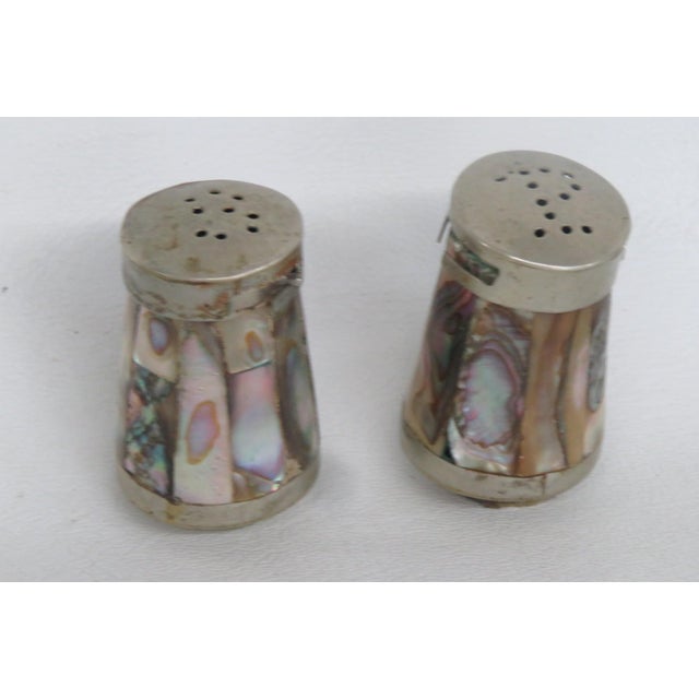 This beautiful Pair of Salt and Pepper Shakers are made of metal and abalone shell. Both Shakers in this lovely pair...