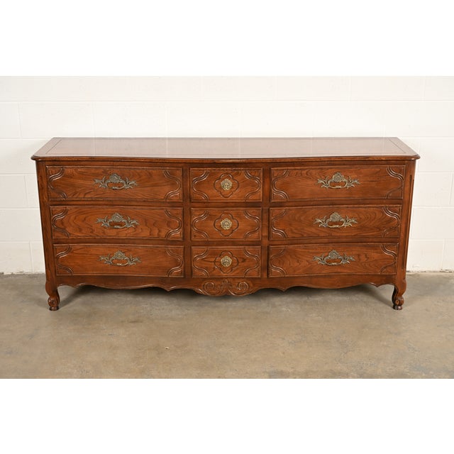 A beautiful French Provincial Louis XV style nine-drawer triple dresser or credenza By Baker Furniture USA, Circa 1980s...