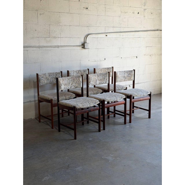 This stunning set of six dining chairs features a clean sculptural silhouette with striking vertical backrest pillars and...