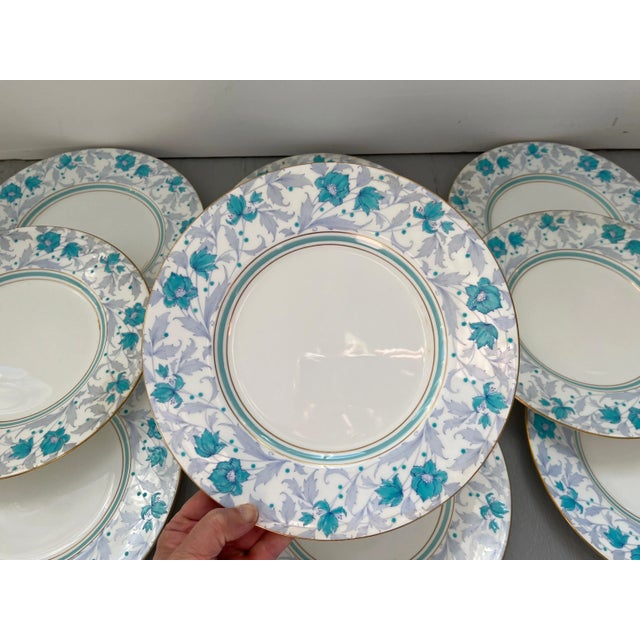 A dozen large Minton porcelain dinner plates decorated in a flower and vine pattern in light blue aqua and light mauve...