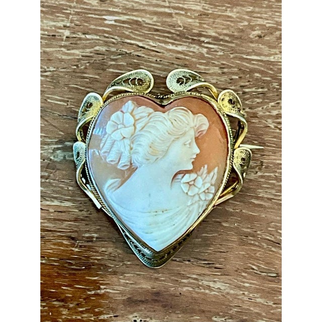 This vintage Victorian 12k gold cameo brooch presents a graceful female profile carved within a romantic heart-shaped...