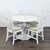 This CB2 dining set includes a modern white round table and four matching white chairs with removable striped seat...
