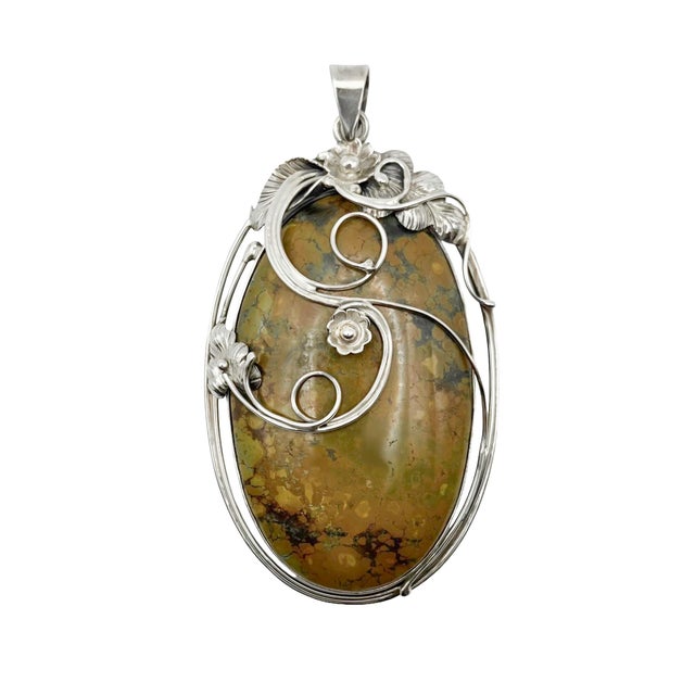 A lovely sterling silver setting for spiderweb turquoise in the shape of an oval. Sterling silver flowers and leaves...