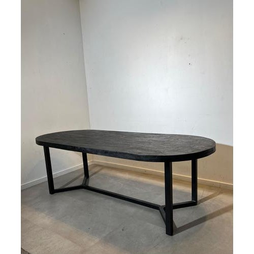 The Denzel dining table is a striking contemporary design featuring a generous oval tabletop in dark stained wood combined...