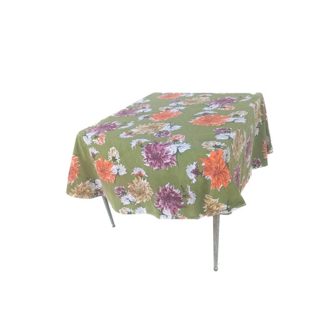 Offered us a vintage Vera Neumann green oval tablecloth decorated with large multi-colored Chrysanthemums in orange,...