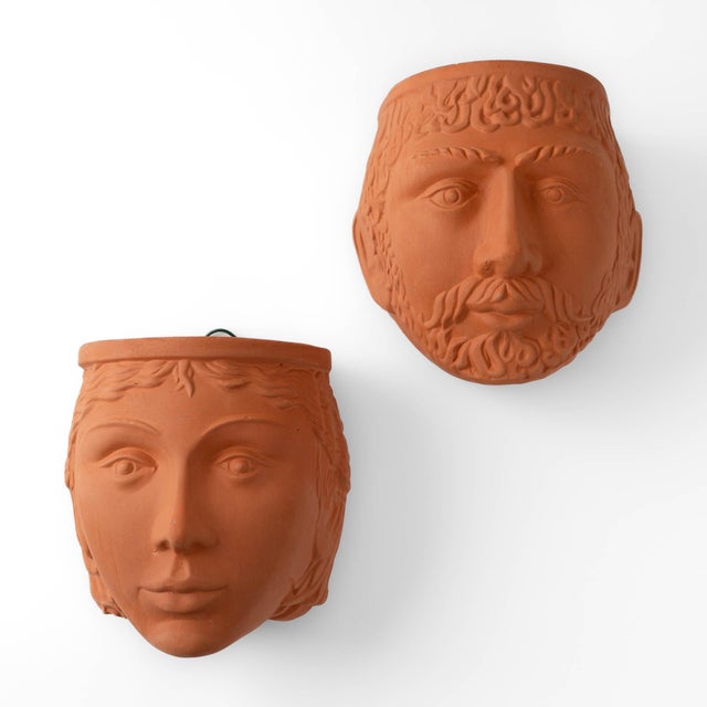 A stunning pair of vintage terracotta wall planters sculpted in the likeness of a male and female mythological deity —...