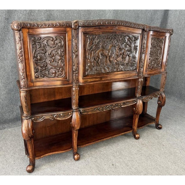 This 19th century Continental drop-front bar is richly carved with ornate scrolling panels and a striking central scene of...