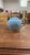 An charming vintage light blue porcelain teapot featuring a lobed body adorned with hand-painted pink rose bouquets and...