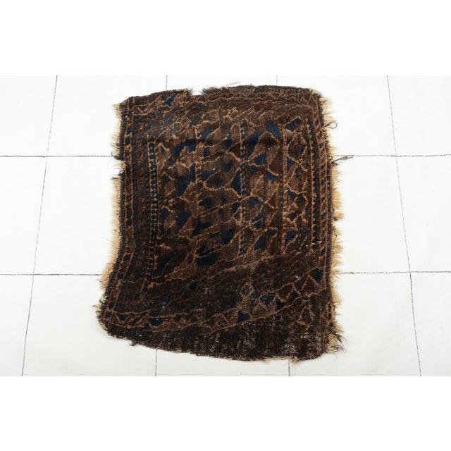 Made with hand-knotted wool circa 1920-1930 from Persia, this 1x2 antique Persian Baluch rug is a bold new addition to the...