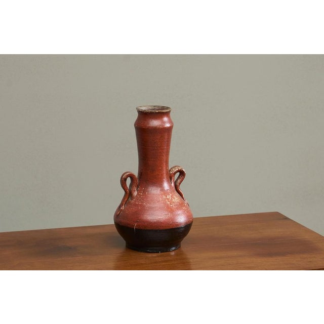 A wonderful and unusual mid 20th century studio pottery vase in stone red and black with beautifully sculptural handles....