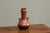 A wonderful and unusual mid 20th century studio pottery vase in stone red and black with beautifully sculptural handles....