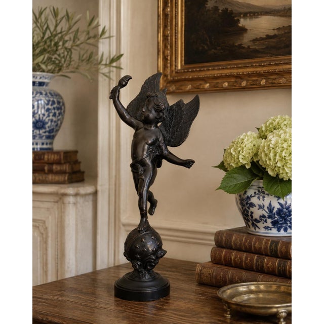 A beautifully modeled late 20th-century winged putto sculpture by Decorative Crafts, rendered in metal with a deep bronze...