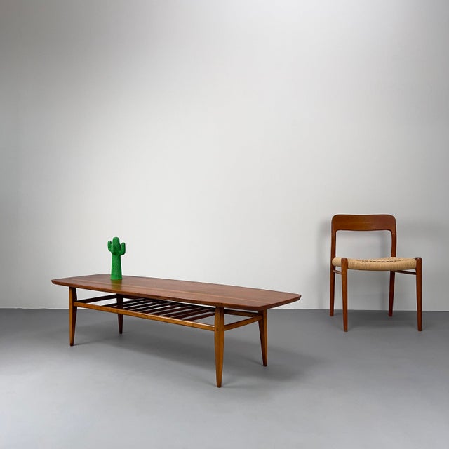 Long, gently rounded tabletop with a practical magazine shelf. Lane furniture is a classic in the USA, but quite rare...