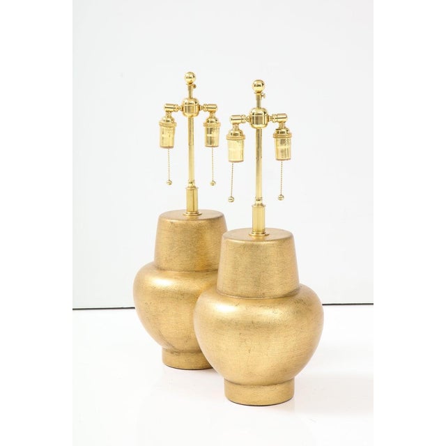 Stunning pair of Wooden lamps with a beautiful gilt leafed finished. The lamps have been Newly re gilded and rewired with...