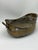 This is a wonderful antique hand-hammered brass vessel, with a low oval form, gently undulating rim, and substantial loop...