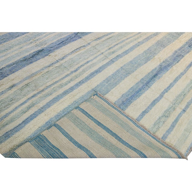 Beautiful Moroccan style handmade wool rug with an ivory and blue field. This Modern rug features a gorgeous all-over...