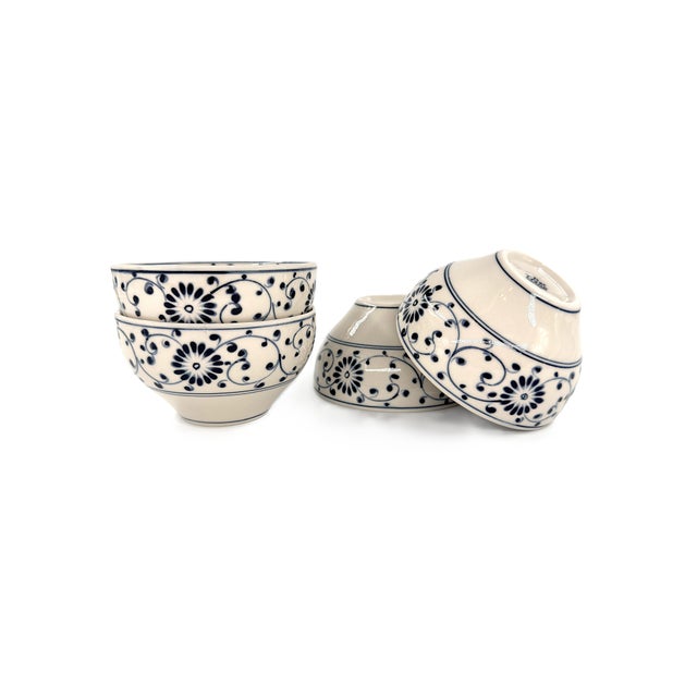 A beautiful set of four Bat Trang ceramic bowls featuring a classic blue-and-white palette and an allover botanical...