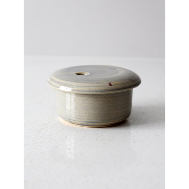 This vintage handmade pottery jar features a soft gray glaze with subtle blue accents. Signed by the artist, the lidded...