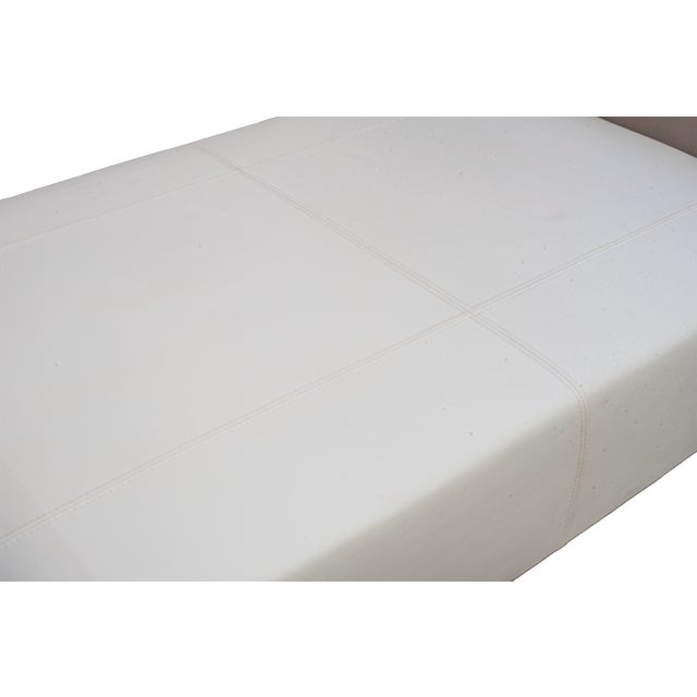 Featuring a minimalist silhouette with a cream leather seat flanked by taupe leather bolstered arms. The bench is...