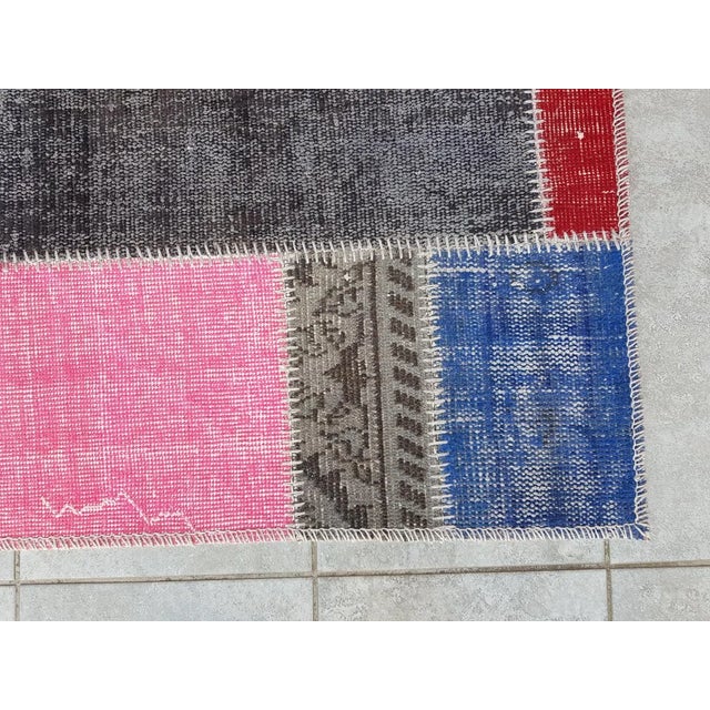 This is a vintage Turkish Oushak rug from the Mid 20th Century. The piece was hand-knotted.