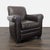 This lounge chair features a timeless design with dark brown leather upholstery and comfy rolled arms. The seat and...