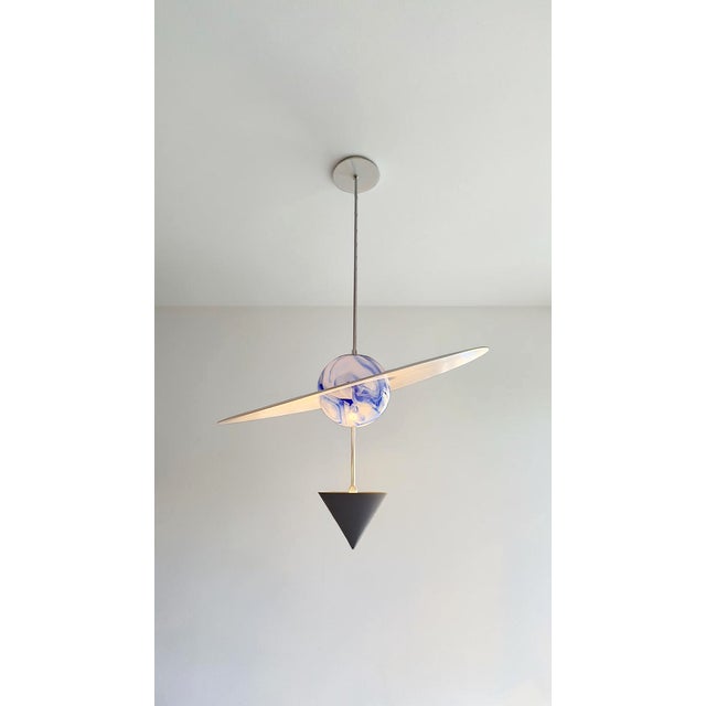 Essential forms, an extremely sophisticated presence. The "Il Cielo" planet combines a blue and white Murano glass globe,...