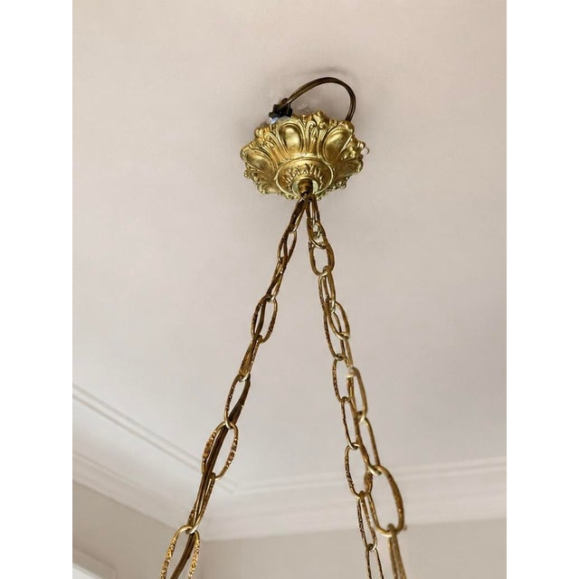 Elegant French Art Deco chandelier from the 1930s, featuring a large frosted pressed-molded glass bowl adorned with a deep...