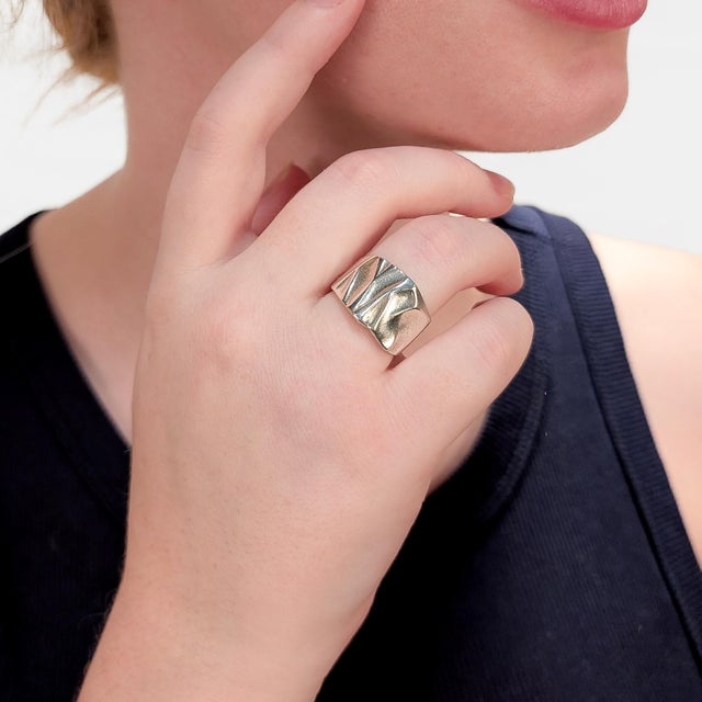 A fine signed Finnish Modernist ring. By Lapponia. In sterling silver. With a textured front and thick, tapering shank....