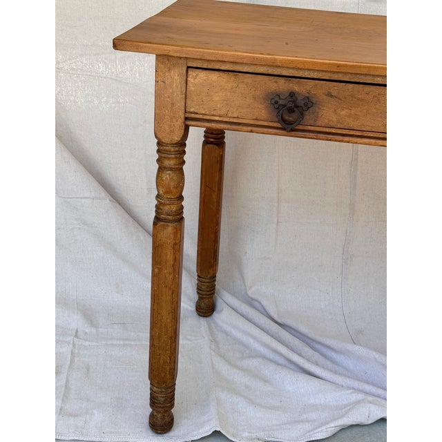 This attractive and timeless English pine side table has a rectangular shape, raised on four turned legs, and has 1 lovely...