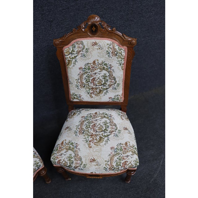 Elegant pair of late Victorian walnut side chairs featuring beautifully carved crest rails with scrolling foliate motifs...