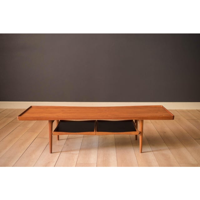 Mid century modern two-tier coffee table in teak designed by Poul Jensen for Selig, Denmark circa 1960's. The table top...