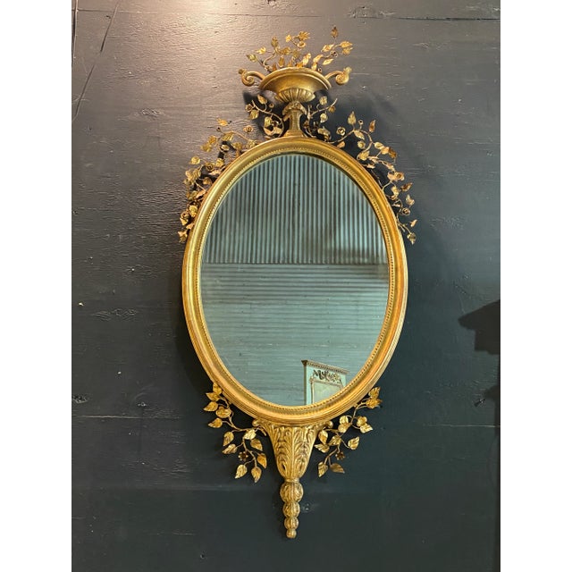 Beautiful Early 20th C Italian gilt wood oval wall mirror, with a filagree of metal leaves and florals extending from the...